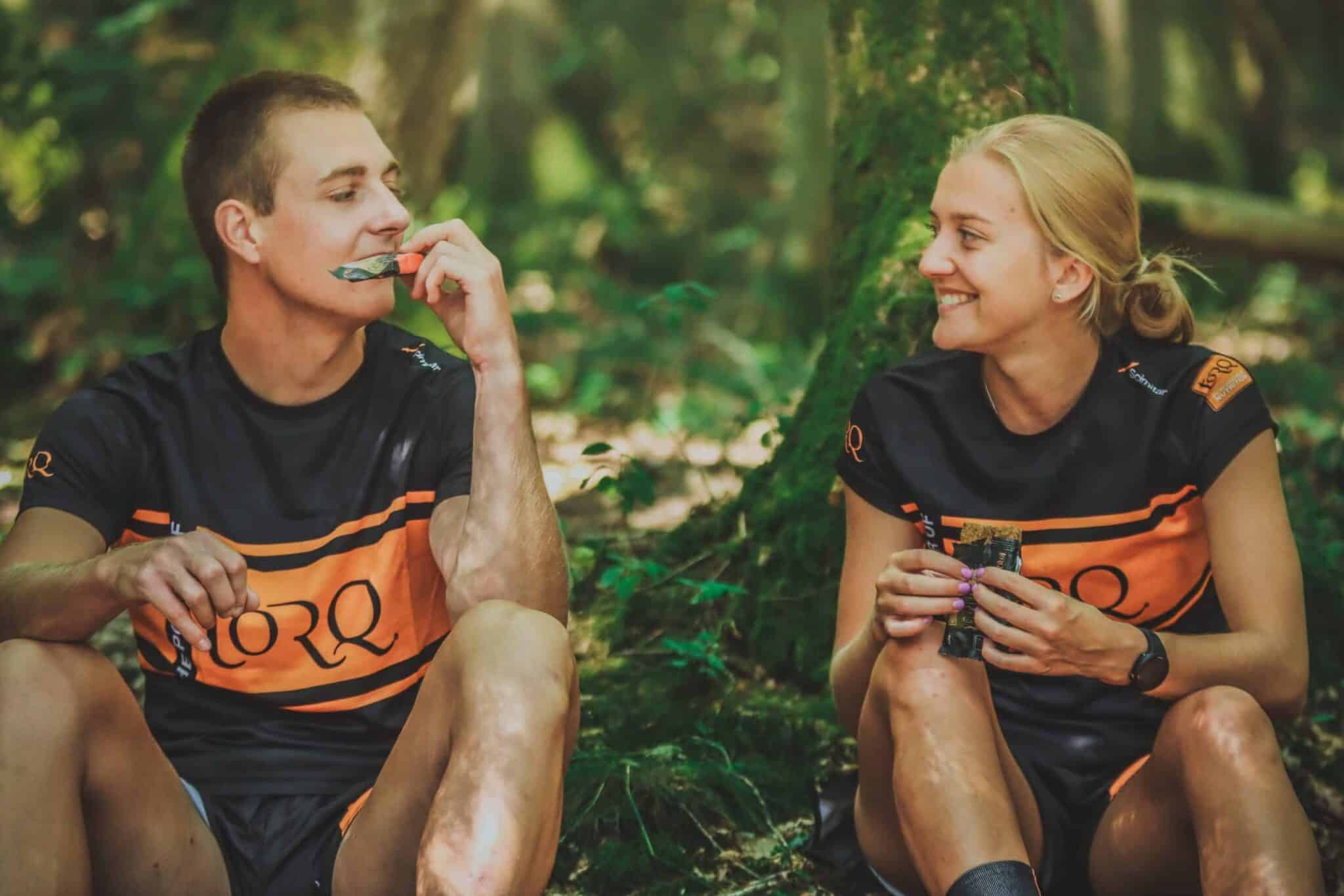 Twee sporters die samen een energiereep eten - hardlopen voeding - RunX