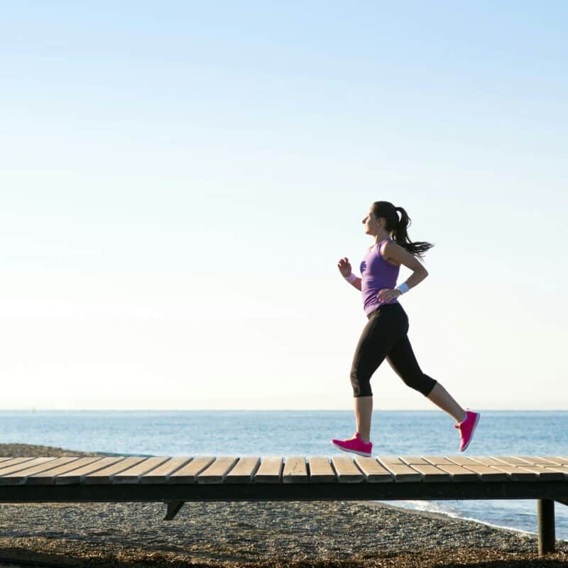 vrouw-bij-zee-aan-het-hardlopen-hardlopen-in-de-zomer-runx