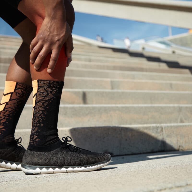 Man met blessure en compressiekousen